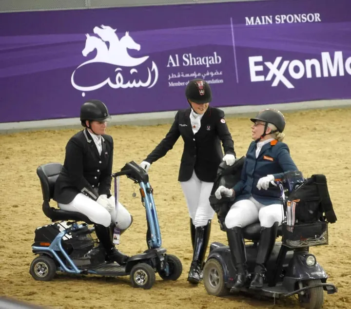 Amanda on her mobility scooter with two other para riders in the Al Shaqab arena