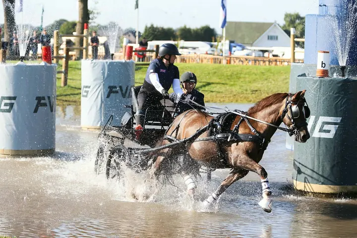 Amanda driving through a water hazard on a marathon course, her back-stepper behind her