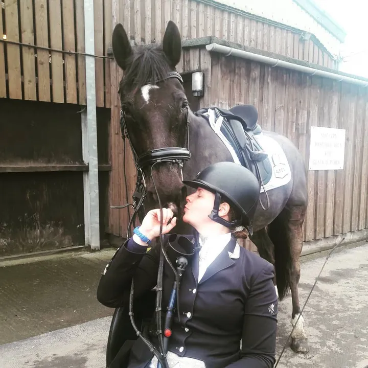 Amanda kissing her dark horse on the nose