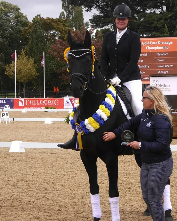 Amanda on New Princess wearing a champion garland while receiving a trophy