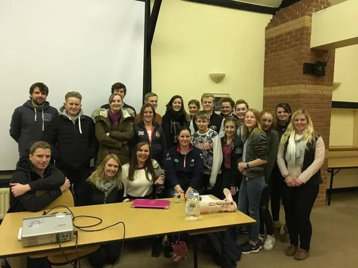 Amanda with a group of young people after a talk in a meeting room